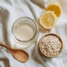 Glass of Oatzempic with oats, lemon, and wooden spoon on white background