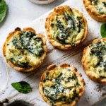 Mini Spinach Artichoke Cups freshly baked on a white board