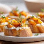 roasted butternut squash crostini with goat cheese on white plate