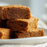 Eggless Peanut Butter Brownies stacked on plate in bright light