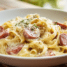Creamy smoked sausage pasta in a white bowl