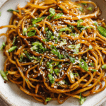 Pan-Fried Potato Noodles with Soy Garlic Sauce served on a white plate