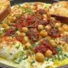 Baked feta with chickpeas served in a dish