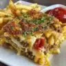 Cheeseburger French Fry Casserole topped with melted cheese in a baking dish