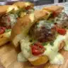 Cheesy meatball subs topped with melted cheese on fresh bread