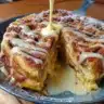 Cinnamon roll pancake skillet topped with icing and cinnamon.