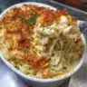 French onion chicken orzo casserole topped with melted cheese and herbs