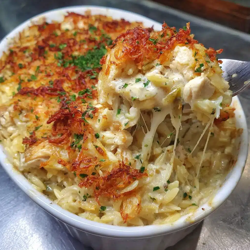 French onion chicken orzo casserole topped with melted cheese and herbs