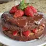 Delicious Strawberry Chocolate Cake topped with fresh strawberries and chocolate ganache.