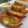 Delicious air fryer potato wedges served on a plate with herbs