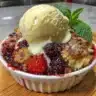 Delicious homemade bumbleberry cobbler topped with fresh berries