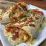 Cheesy Garlic Chicken Wraps served on a plate with fresh herbs