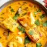 Delicious Coconut Fish Curry served with rice and garnished with herbs.