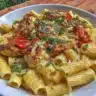 Creamy tomato chicken pasta dish garnished with herbs on a plate