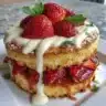 Genoise Shortcake with strawberries and vanilla Swiss buttercream on a serving plate.