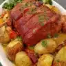 Glazed ham joint served with a variety of colorful fresh vegetables