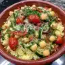 Bowl of healthy Mediterranean Couscous Salad with colorful vegetables and dressing