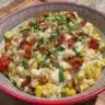 Healthy Street Corn Salad with Greek Yogurt in a bowl, garnished with fresh herbs.