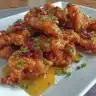 Delicious honey garlic crispy chicken garnished with herbs