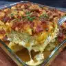 Deliciously cheesy Crack Chicken Casserole topped with crispy bacon and herbs