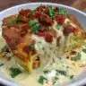 Delicious Mexican Chicken Casserole topped with cheese and garnished with herbs.