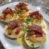 Plate of Million Dollar Bacon Deviled Eggs garnished with crispy bacon bits.