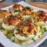 Delicious Pink Deviled Eggs garnished with herbs, a festive appetizer.