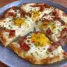 Delicious Pizza Eggs breakfast served on a plate with fresh toppings.