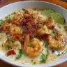 Bowl of Thai Coconut Shrimp Soup garnished with herbs and lime.