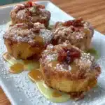 Golden baked rhubarb fritters on a plate, garnished with powdered sugar