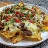 Delicious air fryer cheesy beef nachos topped with jalapeños and cheese