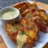 Loaded air fryer potato wedges topped with cheese and herbs