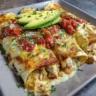 Queso chicken enchiladas served on a plate with toppings