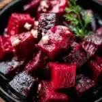 Plate of roasted beets topped with feta cheese and herbs