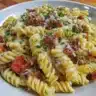 Creamy bacon cheeseburger pasta dish garnished with cheese and bacon.