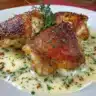 Creamy garlic chicken thighs ready to serve, garnished with herbs.
