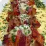 Bacon Wrapped Garlic Parmesan Chicken garnished with herbs on a plate