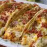 Baked chicken bacon ranch tacos topped with cheese and fresh ingredients