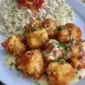 Delicious baked orange chicken served with vibrant orange slices and herbs