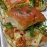 A plate of Bang Bang Chicken Sliders with spicy sauce and garnishes