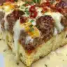Cheesy Loaded Meatloaf Casserole topped with melted cheese and fresh herbs