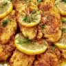 Lemon pepper chicken dinner served on a plate with fresh herbs