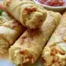 Plate of crispy Chicken Flautas served with salsa and guacamole
