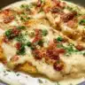 Plate of creamy garlic parmesan chicken garnished with herbs