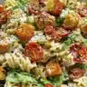 Bowl of Easy Chicken Caesar Pasta Salad with romaine, chicken, and Caesar dressing