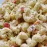 Delicious creamy macaroni salad served in a bowl, garnished with herbs.