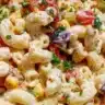 Bowl of colorful Mexican macaroni salad with vegetables and dressing