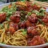 Bowl of Sticky Garlic Chicken Noodles with green onions and sesame seeds