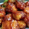 Sticky honey chicken recipe garnished with sesame seeds and green onions