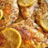 Delicious Lemon Pepper Chicken served with fresh herbs and lemon wedges